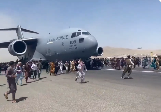 In a desperate move to flee, Afghan's besieged an airport with some hanging on the exterior part of a moving U.S. military aircraft, 15 August 2021 - the day Kabul fell to the Taliban.
